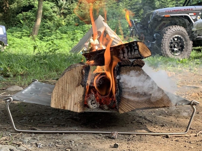 BUSH CRAFT ウルトラライト ファイヤースタンドに大きな薪で焚き火をしている様子