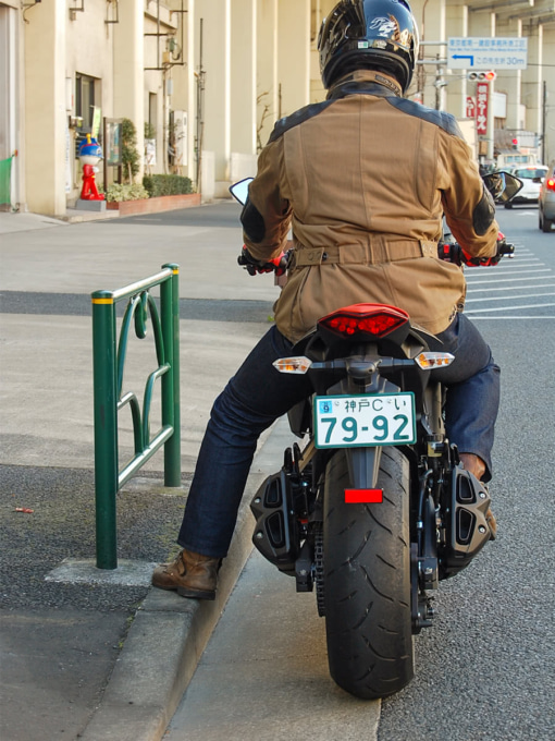 バイクの停車時に道路脇の縁石に足をつけている状態