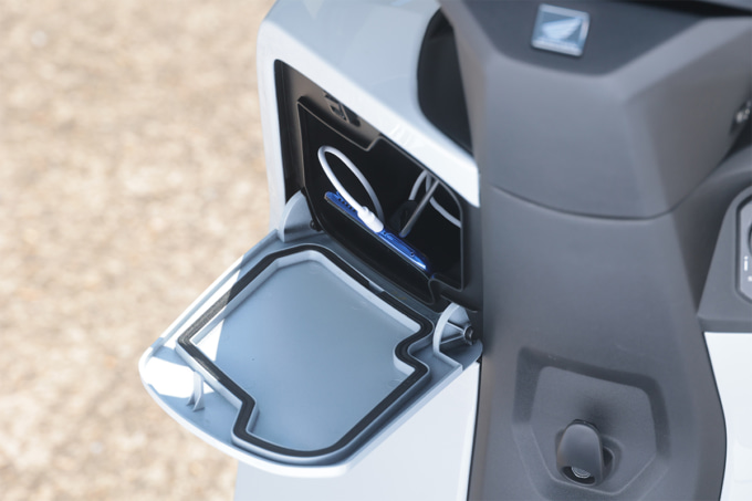HONDA CUV e: グローブボックスに充電中のスマートフォンを収納している図