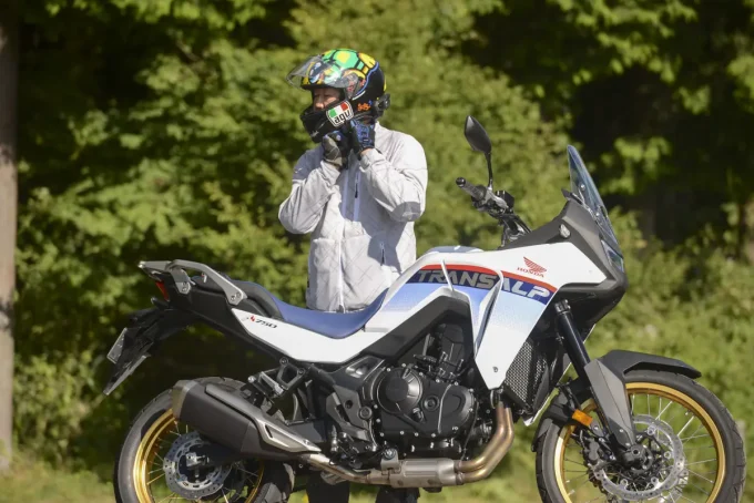 試乗後、ヘルメット姿の高木さんがXL750 TRANSALPの横に立ち、感想を語る場面。